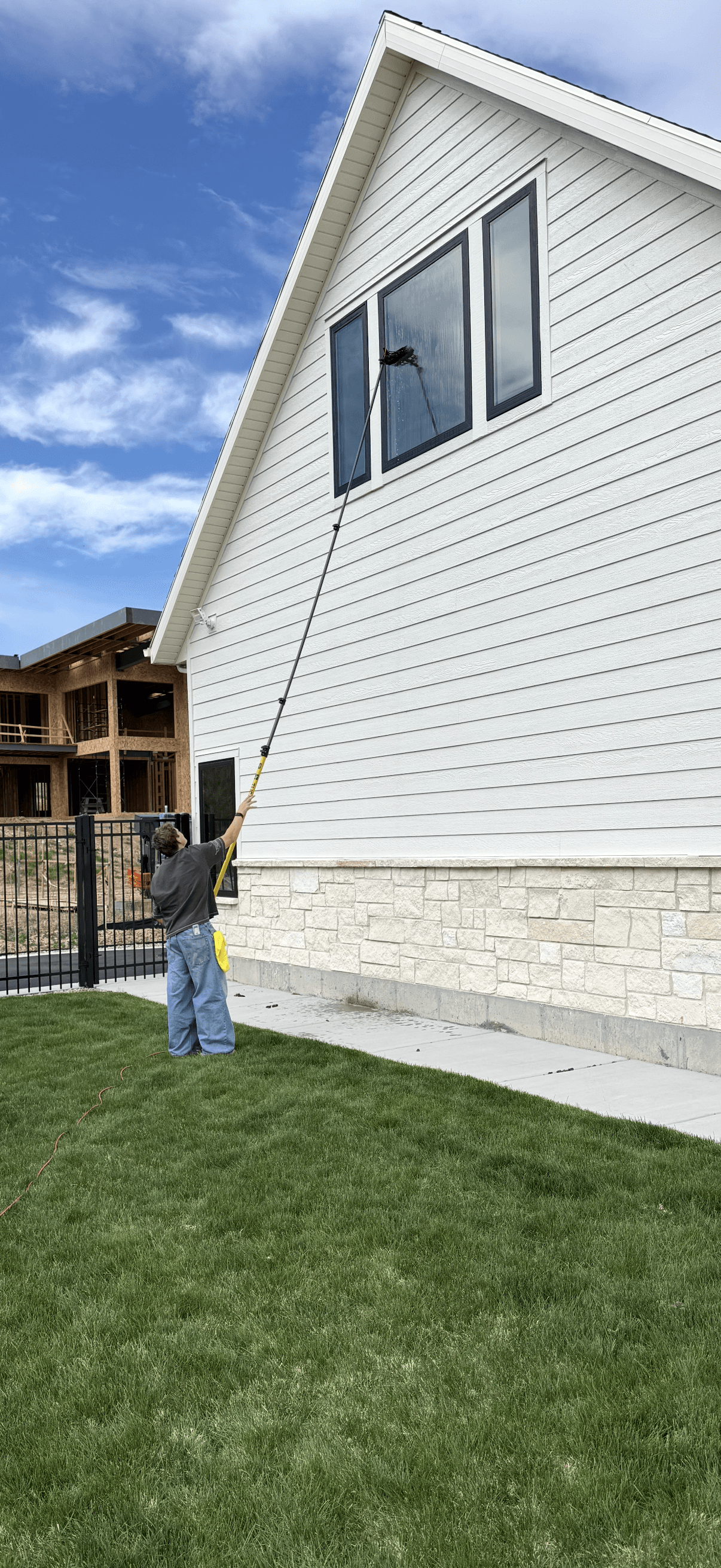 Basin Clear View cleaning upper exterior windows with a water-fed pole.